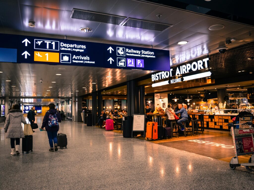 Travelers at Helsinki Airport dining and shopping near departures and arrivals.
